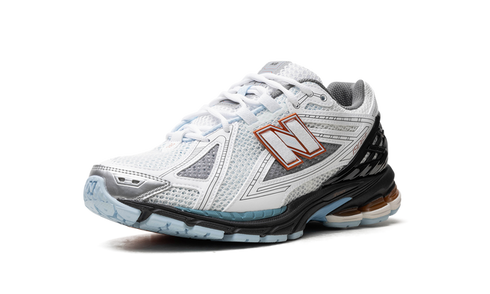 "Close-up of New Balance 1906R logo and mesh details – White Black Copper"